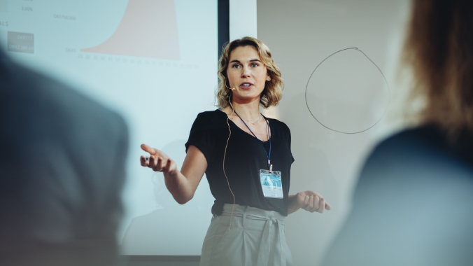 Lecturer presenting at the front of a room.